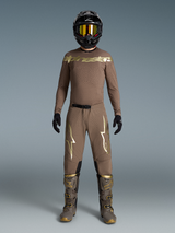Tenue Supertech Air Or Édition Limitée, ensemble motocross beige aux logos dorés, bottes et casque assortis.