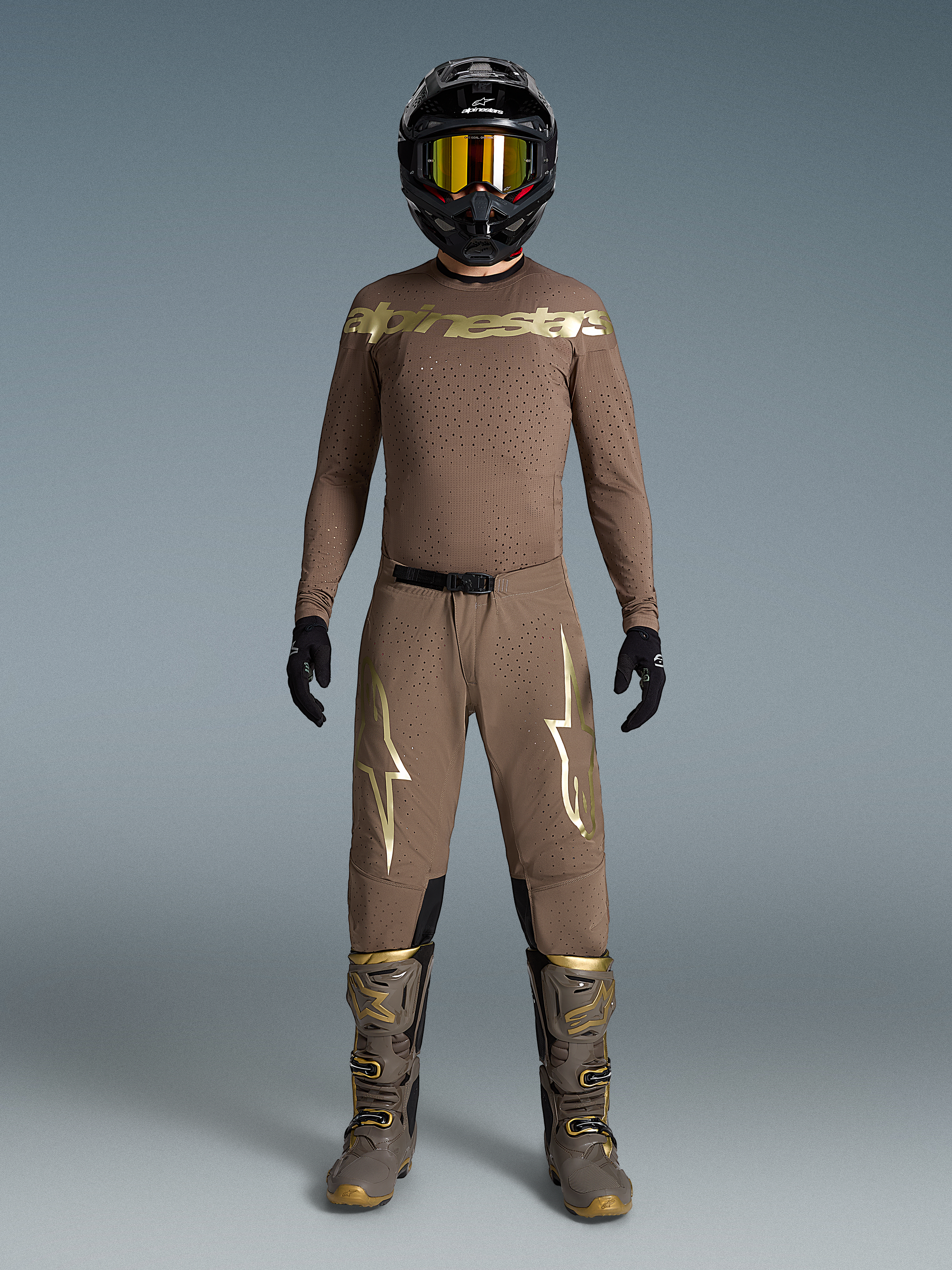 Tenue Supertech Air Or Édition Limitée, ensemble motocross beige aux logos dorés, bottes et casque assortis.
