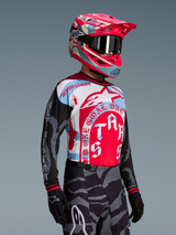 Maillot Techstar Beast Coast Édition Limitée rouge et bleu, porté avec casque assorti et pantalon de motocross camouflage.