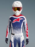Maillot Alpinestars Techstar Unity, maillot de motocross édition limitée rouge, blanc et bleu, coupe athlétique sur un pilote.