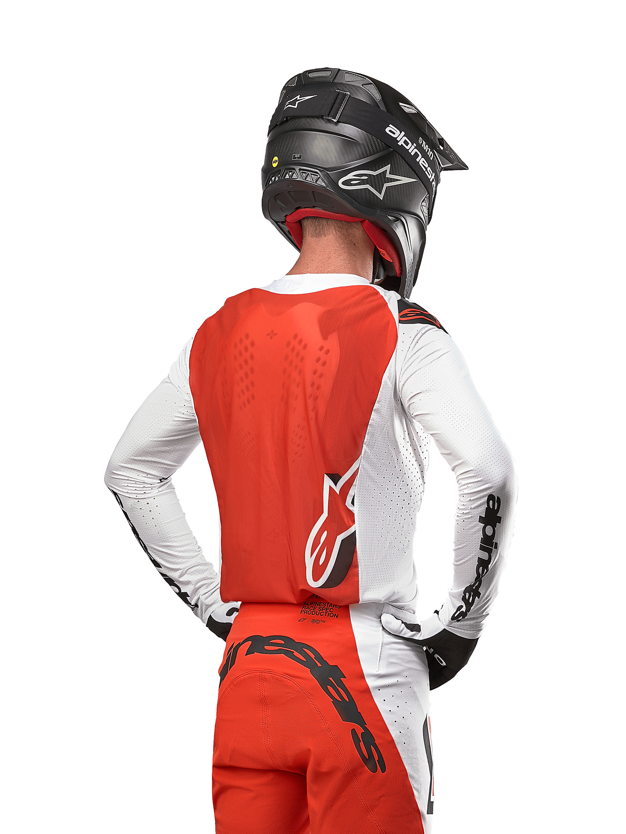 Motocross-Fahrer im 2024 Supertech Ward Jersey in White Hot Orange, Rückansicht mit orangefarbenem Rückenpanel und weißen Ärmeln mit schwarzem Alpinestars-Branding, kombiniert mit passender Hose und einem schwarzen Helm, professionelle Ausrüstung für den Offroad-Rennsport