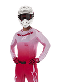 Alpinestars 2024 Supertech Dade Trikot, Motocross-Rennausrüstung, Design mit Farbverlauf in Red Berry Lilac, langärmliges Trikot mit lasergeschnittenen Perforationen, getragen von einem Fahrer mit weißem Helm sowie passenden roten Handschuhen und Hosen, professionelles Motocross-Set auf weißem Hintergrund
