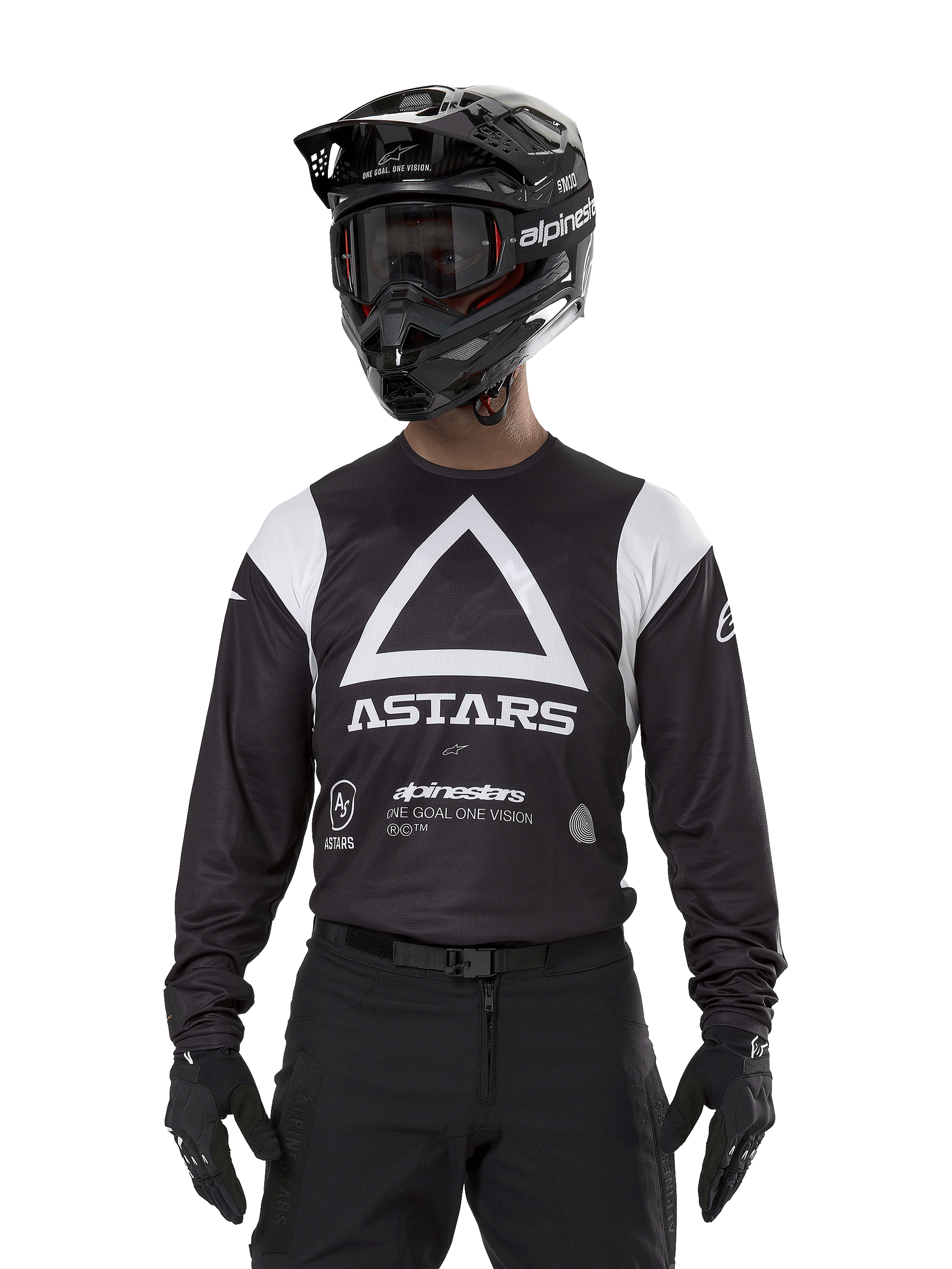 Maillot Alpinestars Techdura, noir, arborant un grand motif triangulaire blanc sur la poitrine avec le logo ASTARS et des empiècements blancs aux épaules, porté par un pilote avec un casque de motocross noir, des lunettes et une tenue tout-terrain noire assortie.