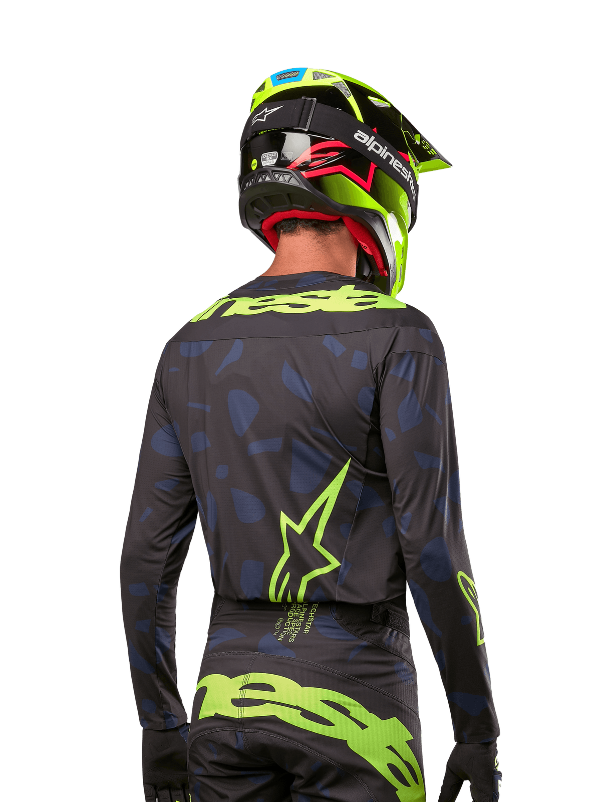 Vue arrière d'un pilote de motocross portant le maillot Alpinestars Techstar Rantera 2024 en Noir Marine Jaune Fluo, avec des logos jaune fluo proéminents au dos, associé à un pantalon de motocross assorti et un casque jaune fluo pour un look de course tout-terrain complet.