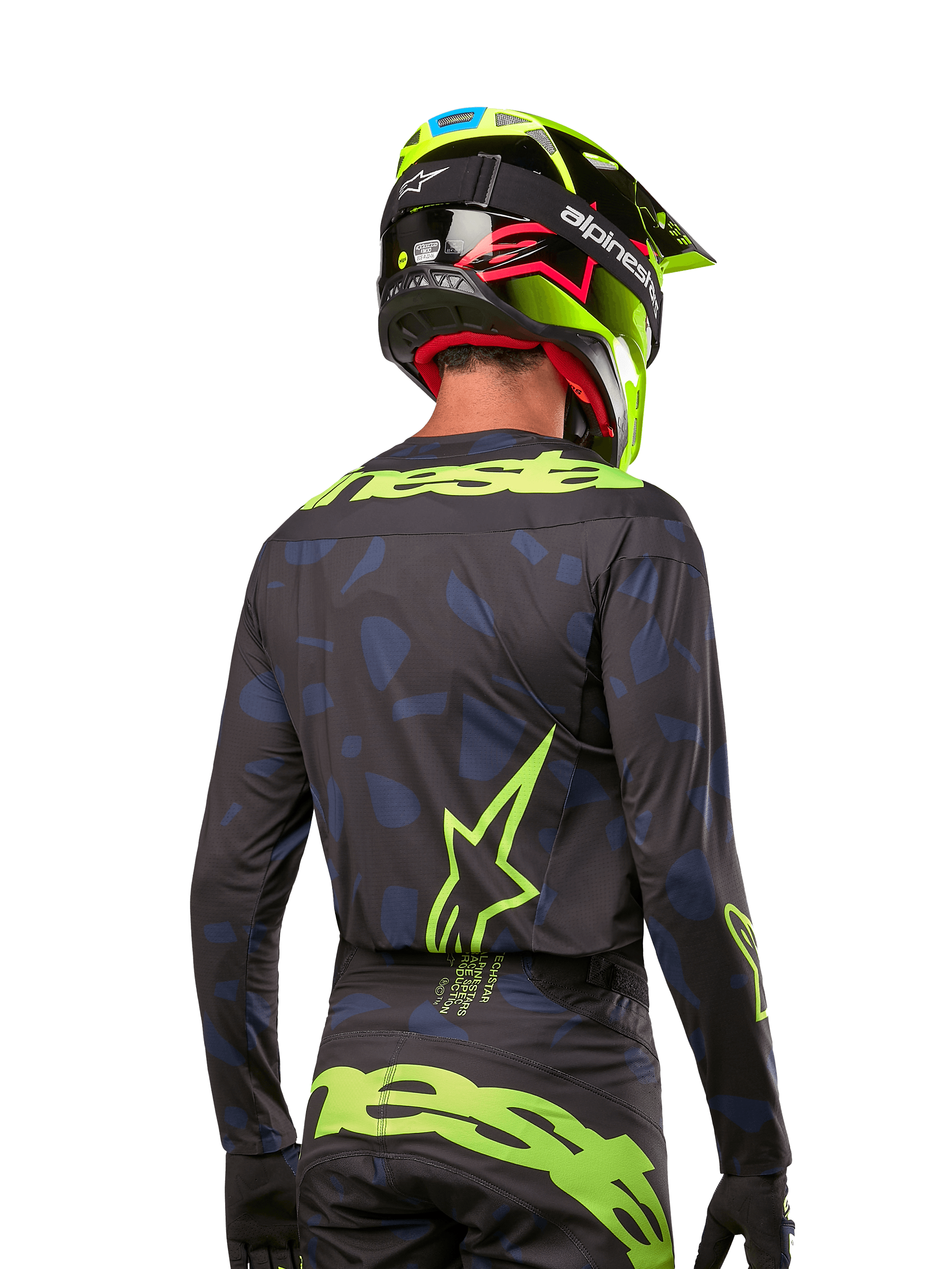 Vue arrière d'un pilote de motocross portant le maillot Alpinestars Techstar Rantera 2024 en Noir Marine Jaune Fluo, avec des logos jaune fluo proéminents au dos, associé à un pantalon de motocross assorti et un casque jaune fluo pour un look de course tout-terrain complet.