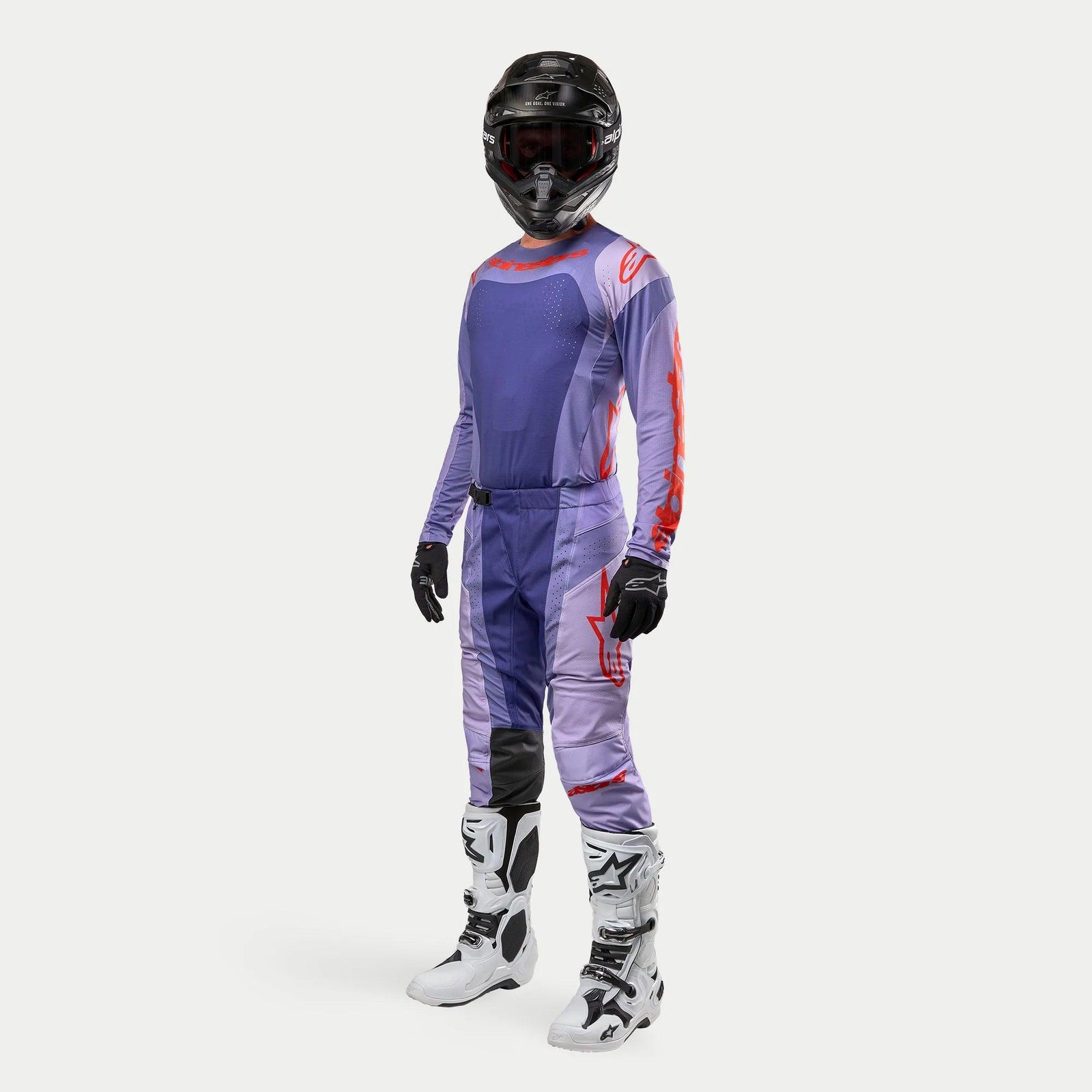 Tenue de motocross complète Alpinestars Techstar Ocuri 2024, maillot et pantalon violets avec détails orange vif, casque noir, gants noirs et bottes blanches, équipement de protection technique pour le tout-terrain