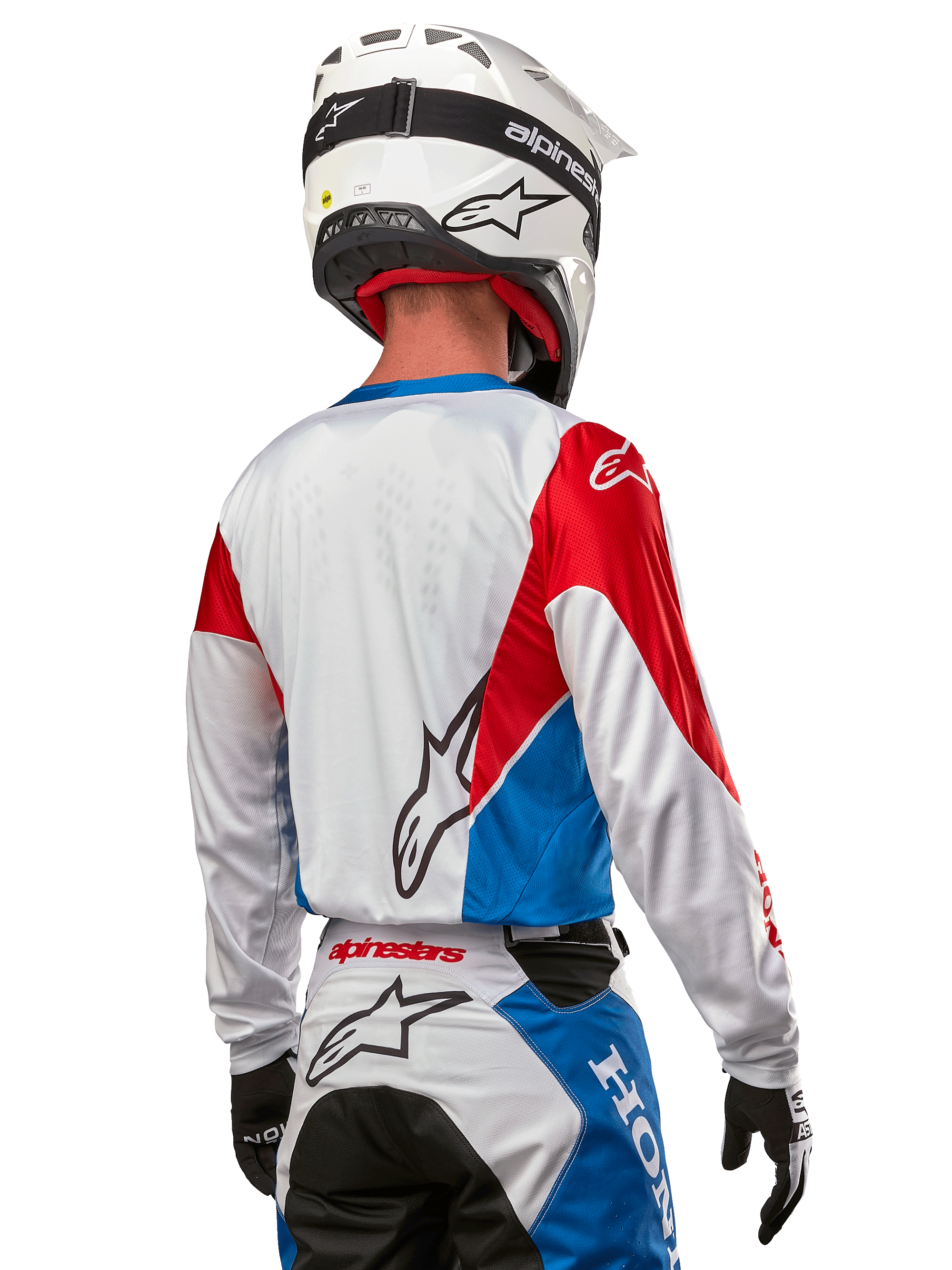 Motocross-Fahrer im Alpinestars Honda Racer Iconic Trikot, Rückansicht, Weiß mit leuchtend blauen und leuchtend roten Paneelen, markantes Alpinestars-Logo auf der Rückseite, kombiniert mit weißem Motocross-Helm und passender Rennhose.