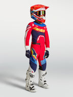 Alpinestars jeugd Supertech Dyna jersey en gearset 2027 in rood en navyblauw, motocrossuitrusting met witte motorlaarzen.