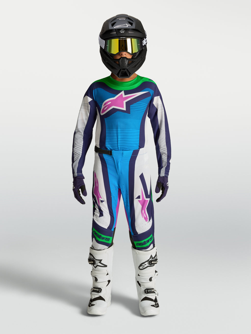 Alpinestars jeugd Supertech Maven gear set, blauw-wit motocrosspak met groene en roze accenten, op model.