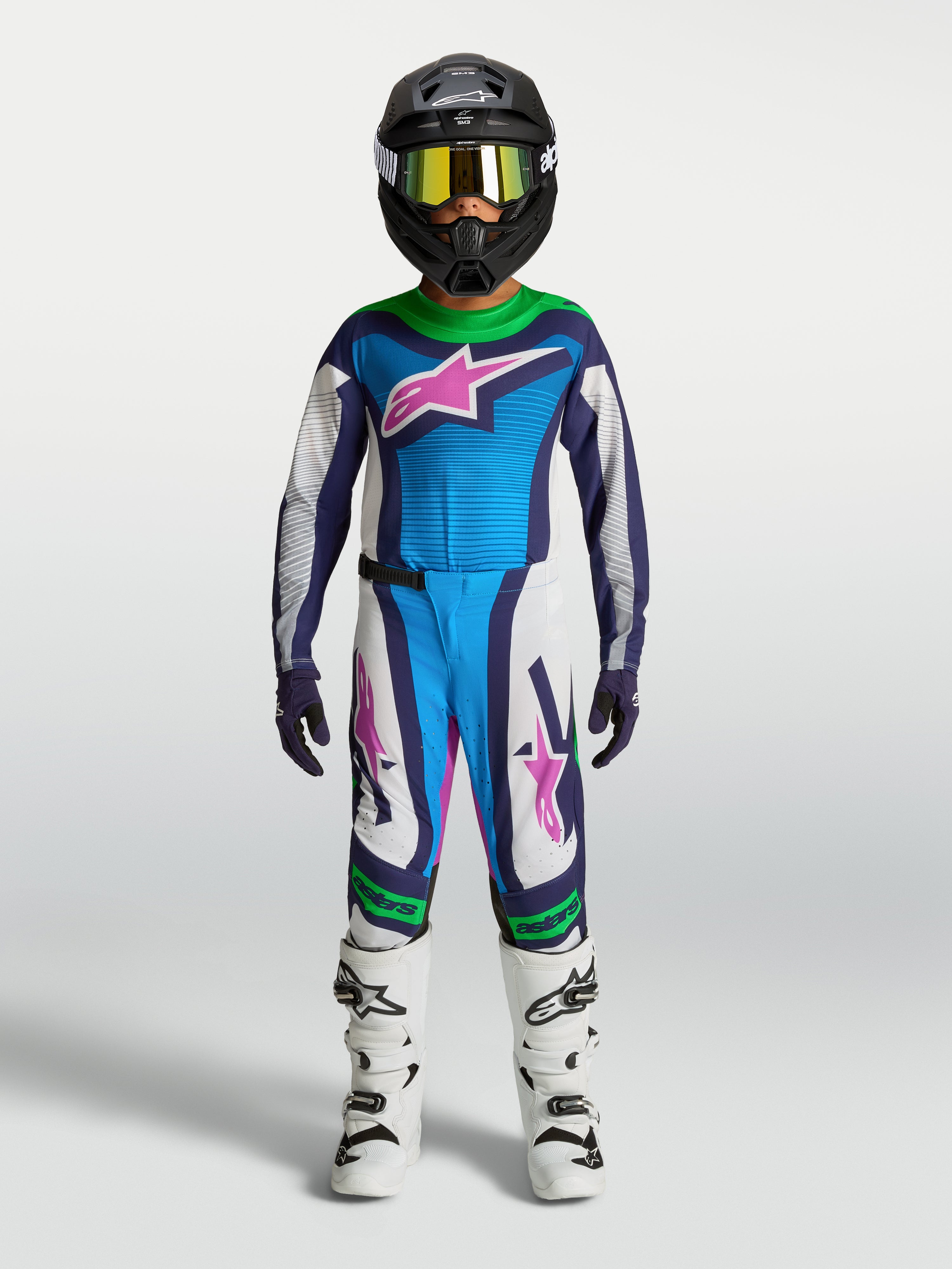 Alpinestars jeugd Supertech Maven gear set, blauw-wit motocrosspak met groene en roze accenten, op model.
