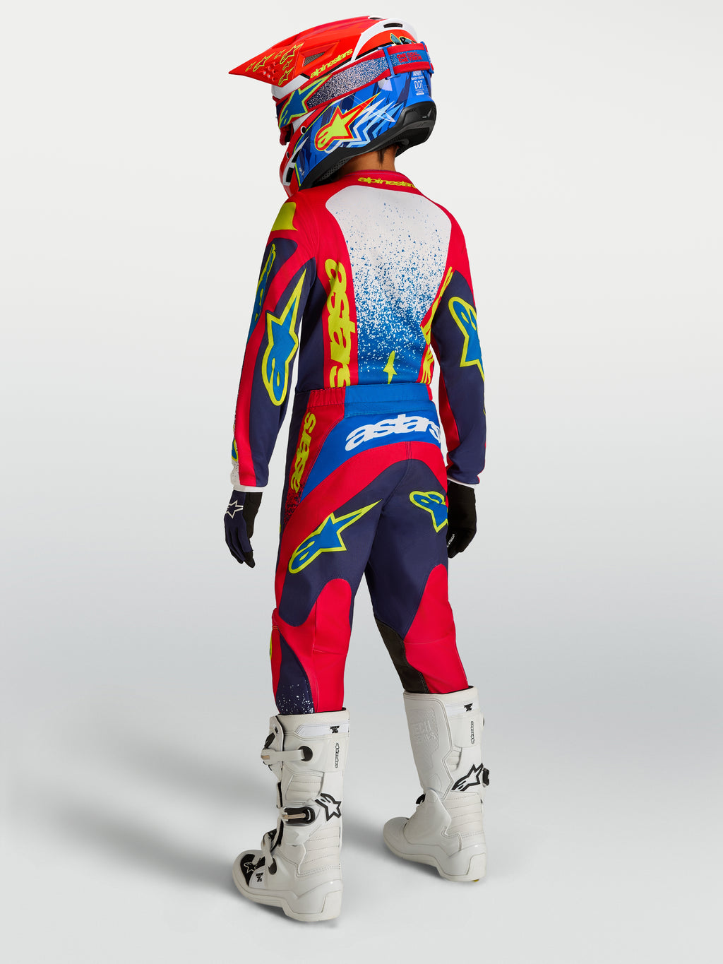 Alpinestars Jugend Fluid Drag Gear Set, Motocross-Outfit in Blau und Rot, Rückansicht mit weißen Motorradstiefeln.