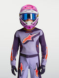 Maillot Fluid Hunt Junior 2027 d'Alpinestars, tenue de motocross violette et rose fluo avec casque et masque.