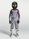Alpinestars Jeugd Fluid Amber jersey en gear set, motorcrossuitrusting, grijs en zand, zwarte helm en witte motorlaarzen.