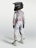 Alpinestars Jeugd Fluid Lone gearset 2027, motocrosskleding in grijs camouflage en wit met rood, achteraanzicht op model.