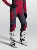 Alpinestars Stella Techstar Swan broek, dames-motocrossbroek, rood en donkergrijs, gedragen met witte Tech 10 motorlaarzen.