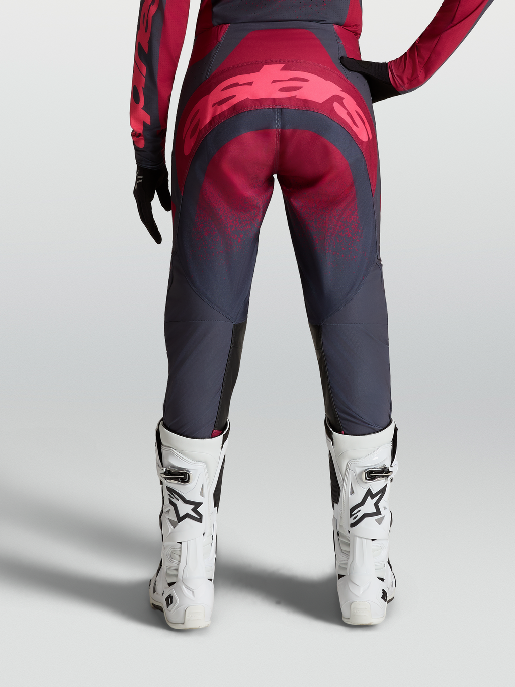Alpinestars Stella Techstar Swan Hose, Damen-Motocross-Ausrüstung, Rot und Grau, Rückansicht mit weißen Rennstiefeln