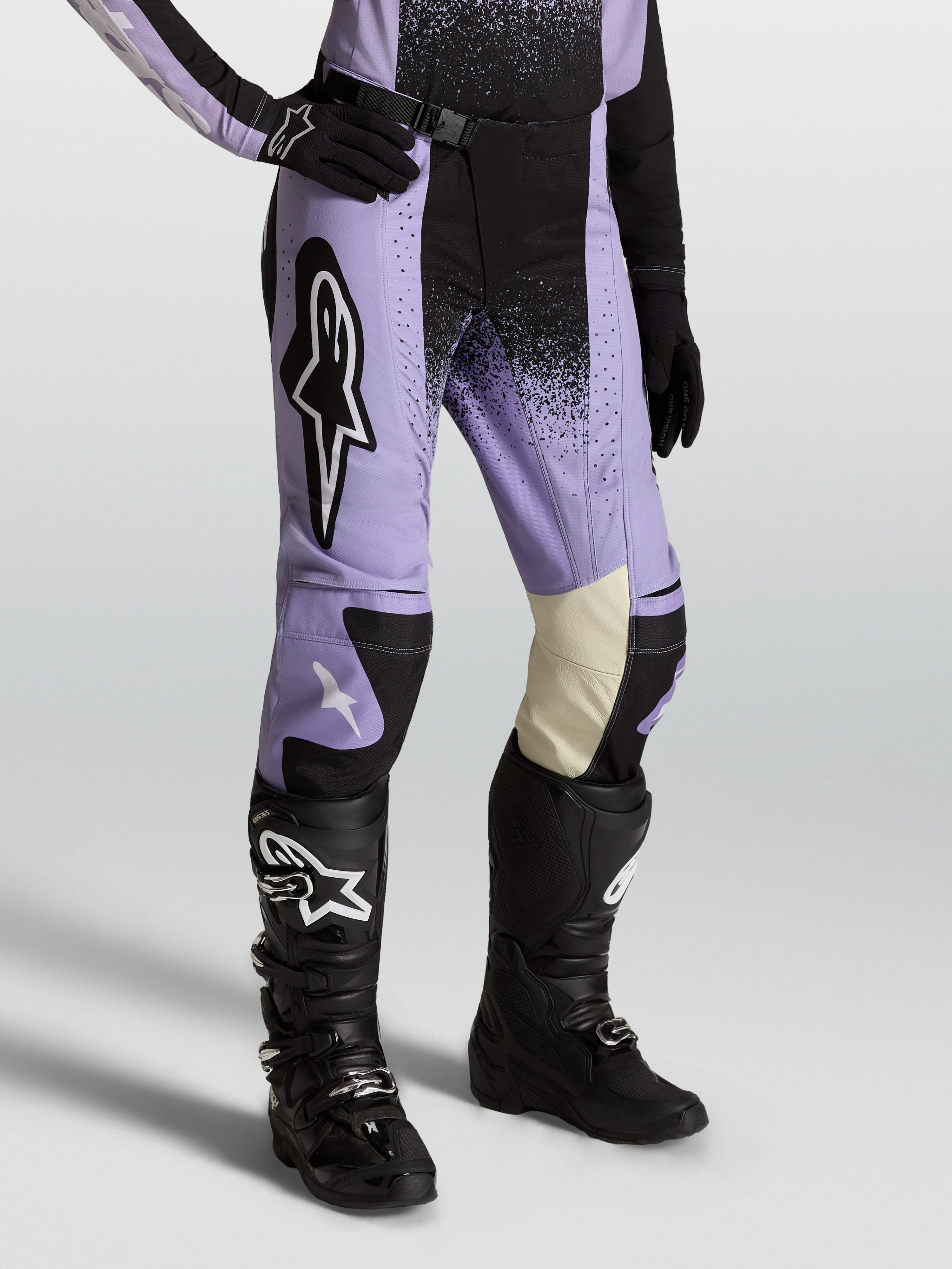 Alpinestars Stella Techstar Swan Broek, dames-motocrossbroek in paars en zwart, lederen binnenknieën, gedragen met Tech 7 laarzen.