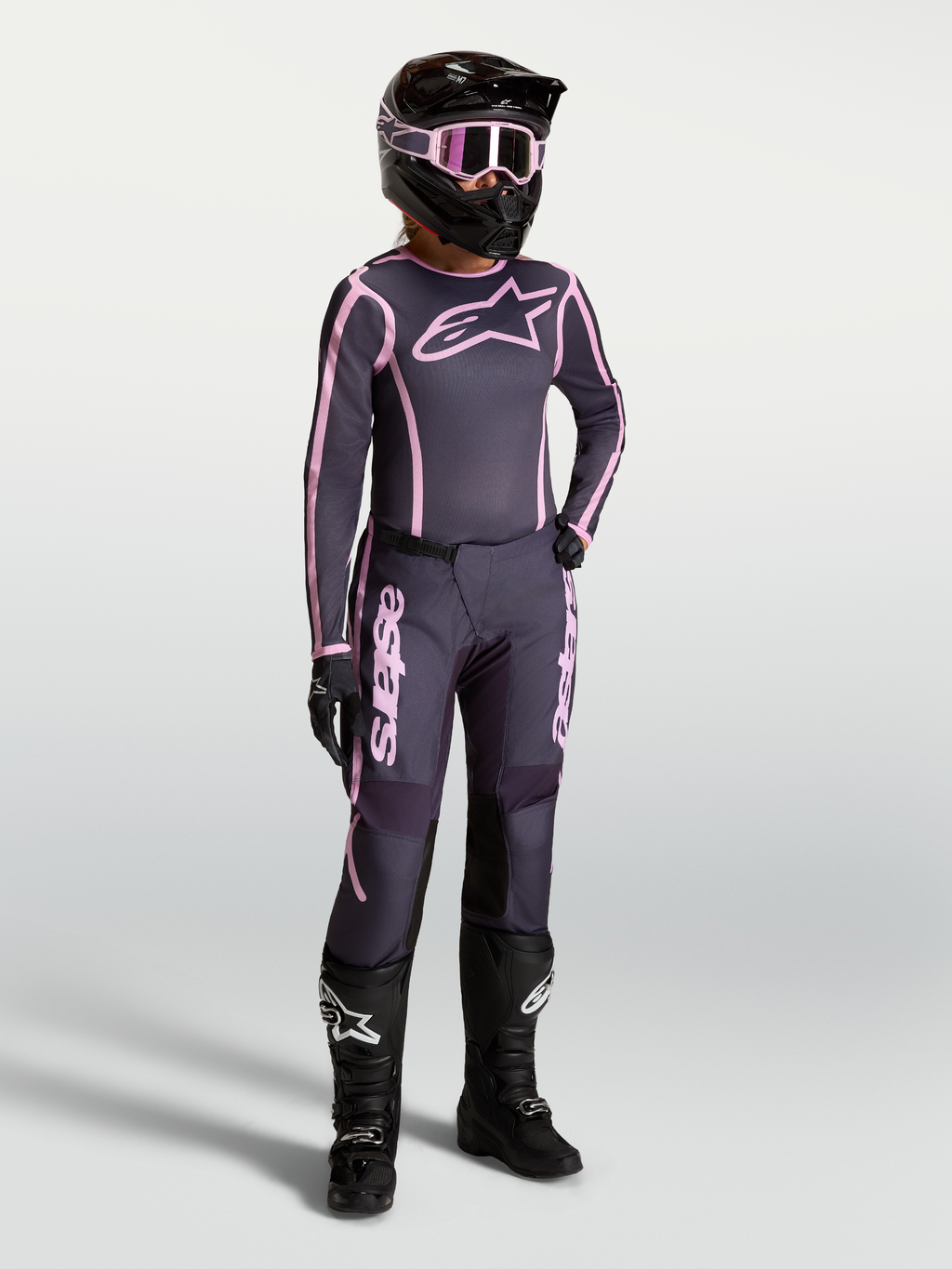 Alpinestars Stella Fluid Apex V2 jersey en kledingset, dames-motocrossoutfit in grijs en roze met zwarte motorlaarzen.