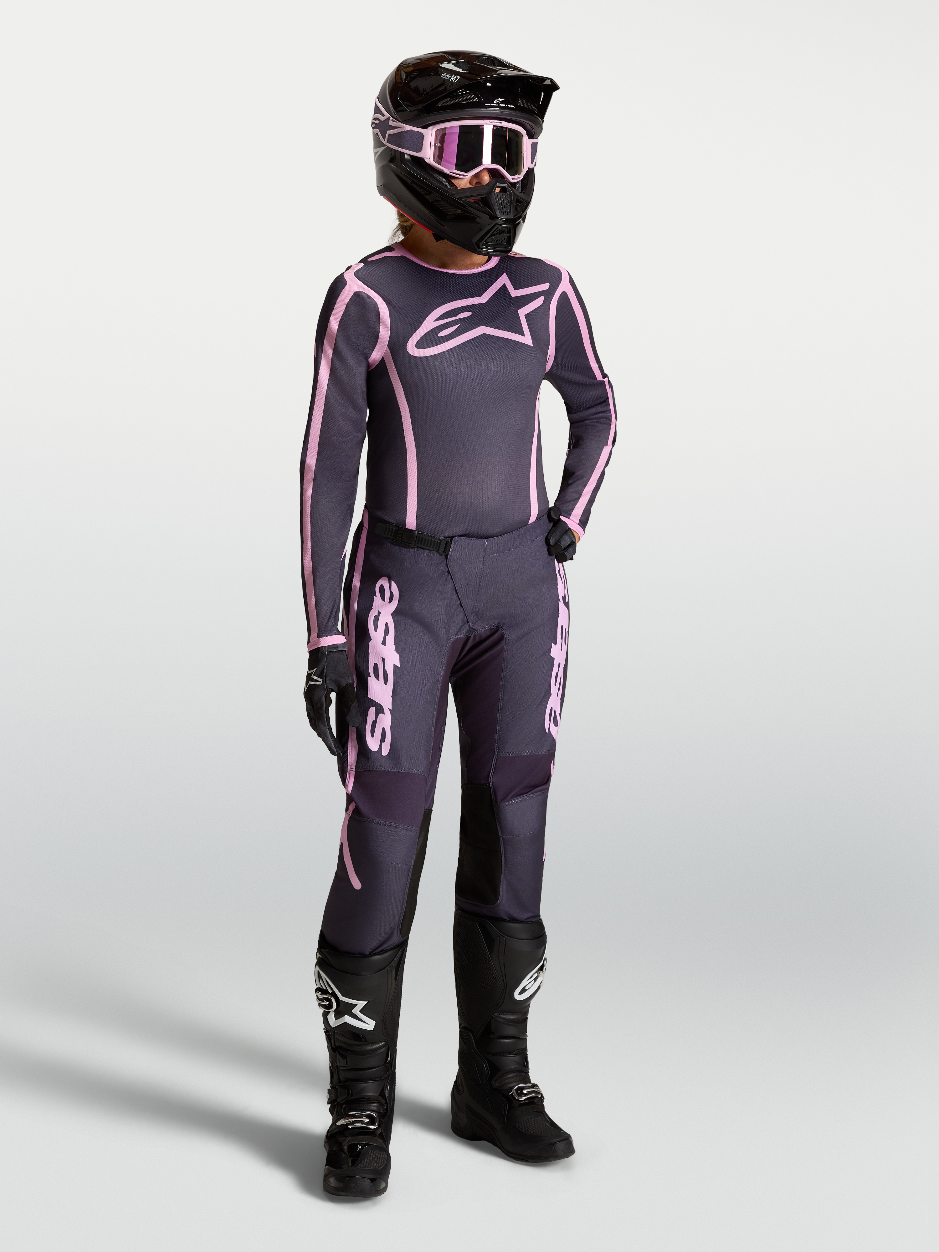 Alpinestars Stella Fluid Apex V2 jersey en kledingset, dames-motocrossoutfit in grijs en roze met zwarte motorlaarzen.