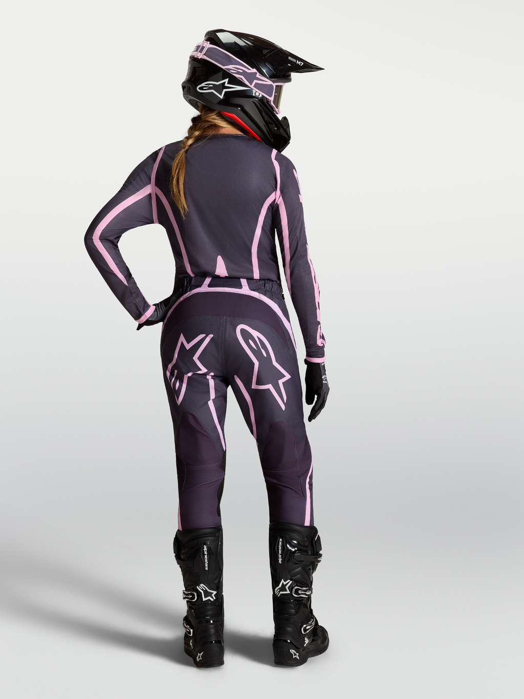 Alpinestars Stella Fluid Apex V2 jersey en gear set voor dames, grijs en roze motocrossoutfit in achteraanzicht.
