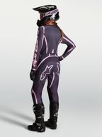 Alpinestars Stella Fluid Apex V2 jersey en kledingset voor dames, grijs en roze motocrossoutfit met zwarte motorlaarzen.