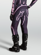 Alpinestars Stella Fluid Apex V2 broek, dames motorcrossbroek in grijs en roze, gedragen met zwarte Tech 7 laarzen.