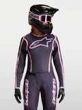 Alpinestars Maillot Stella Fluid Apex V2, maillot de motocross pour femme, gris et rose, coupe athlétique ergonomique, porté par un mannequin avec casque et gants assortis