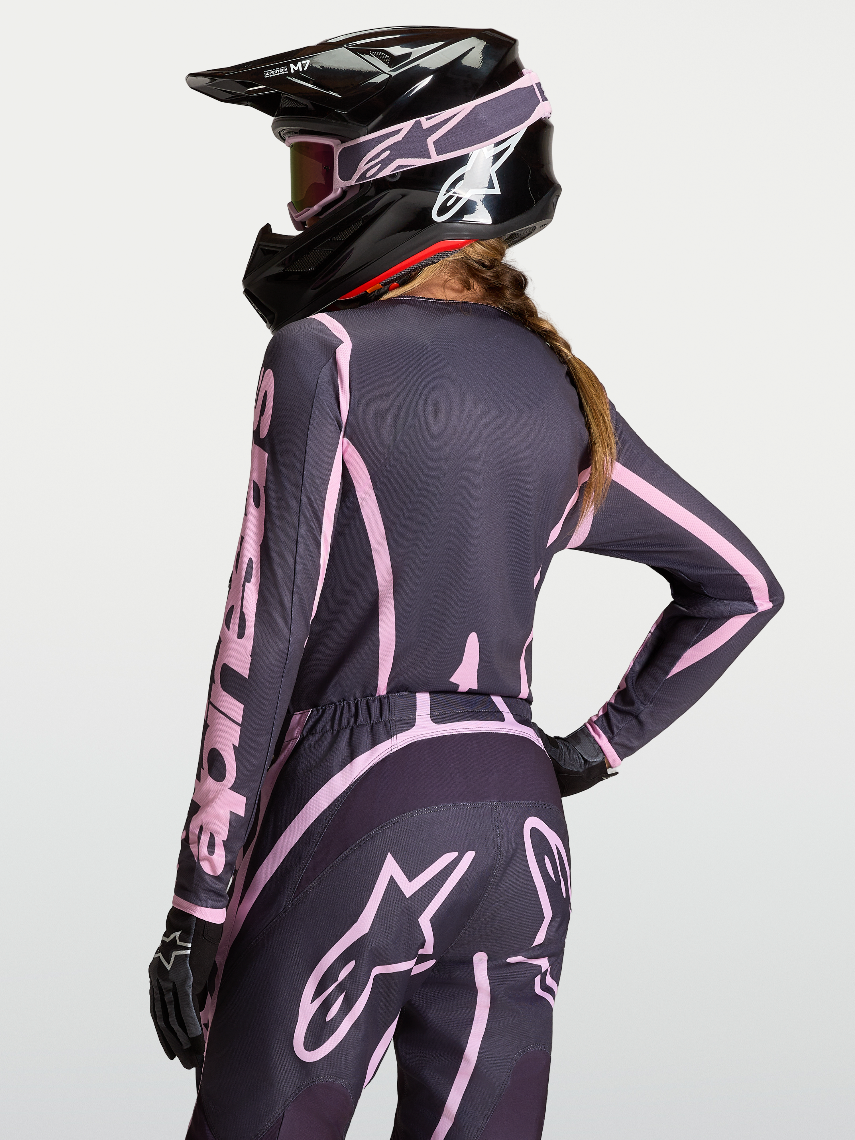 Stella Fluid Apex V2 jersey, dames motocross trui in grijs en roze, model met zwarte helm en bijpassende broek.