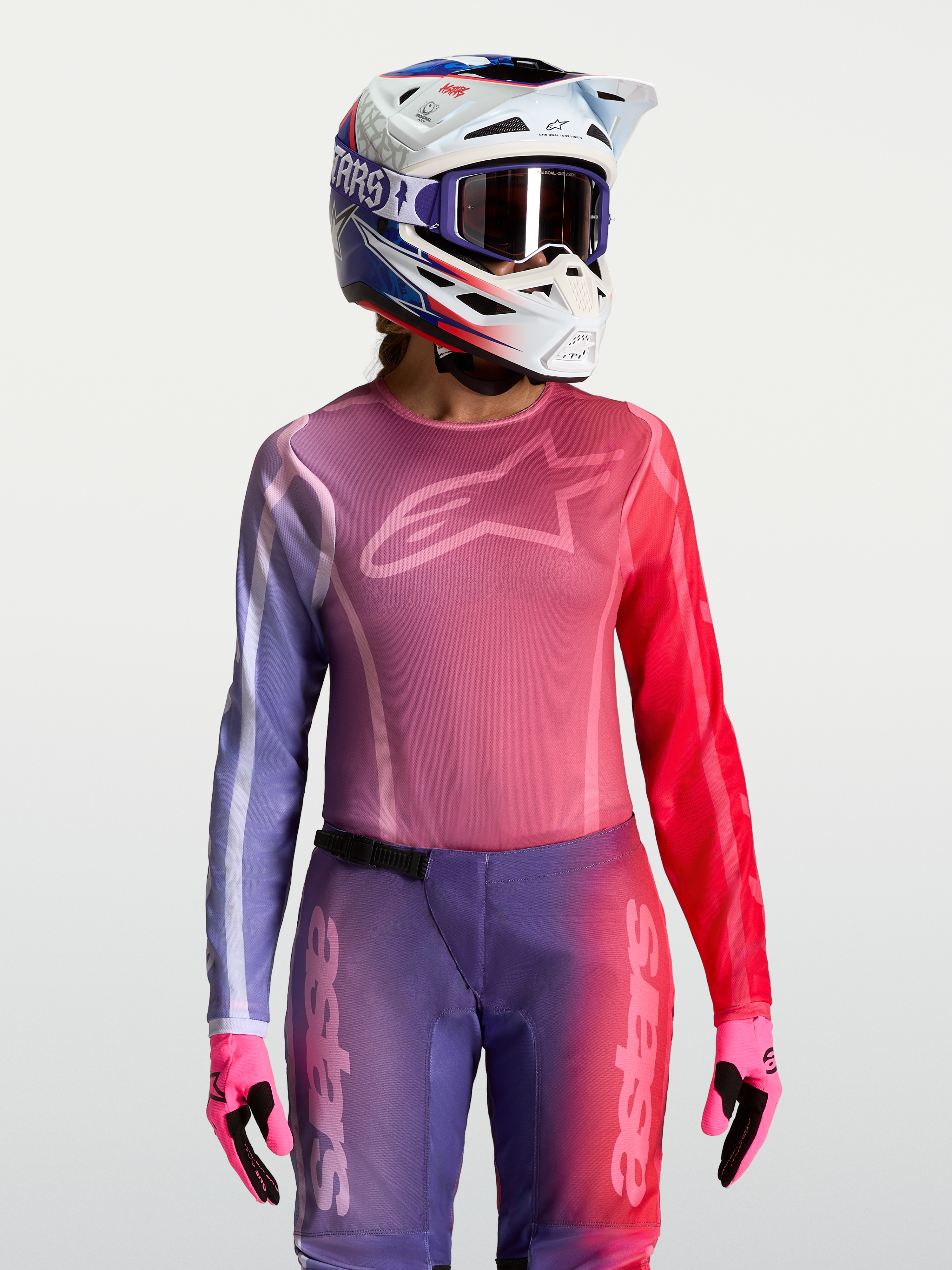 Alpinestars Stella Fluid Kepler Jersey, women's motocross racing top in purple and rouge red, featuring a moisture-wicking polyfabric construction with an athletic fit, paired with a matching helmet and gloves.