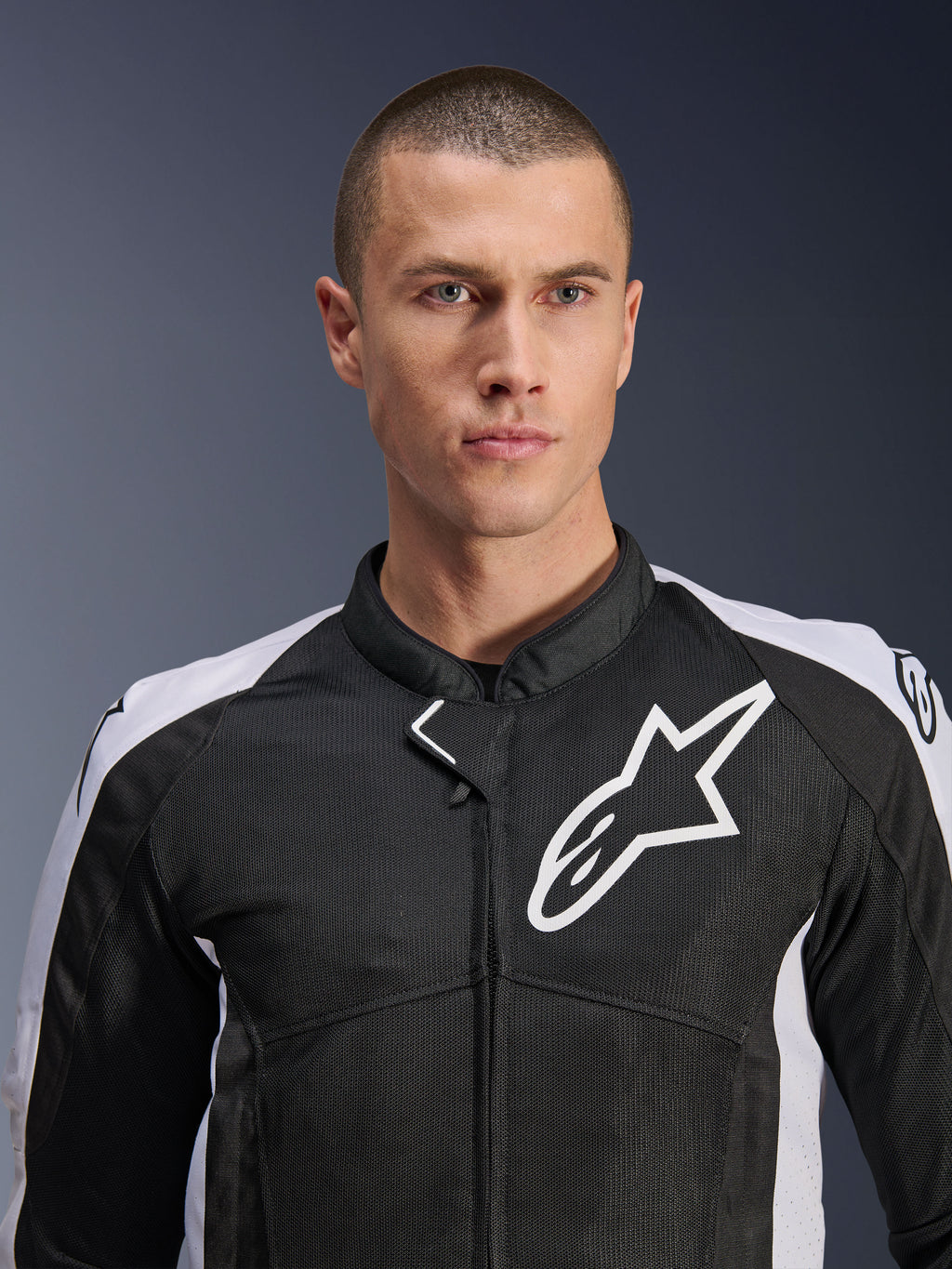 Mannelijk model draagt de Alpinestars Viper Air V4 Jas in zwart en wit, voorzien van tech mesh-panelen voor luchtstroom, wit Alpinestars-sterlogo op de borst, sportieve motoruitrusting voor de weg