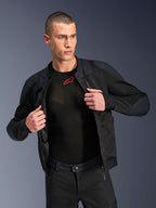 Alpinestars Troop-Air Pro Jas, zwart, hoogwaardige technische gepantserde doorwaaijas met mesh-constructie, open gedragen over een zwarte basislaag met een rood logo, gecombineerd met een bijpassende mesh motorbroek, urban contemporary rijstijl