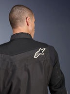 Blouson Alpinestars T-Dyno Air, blouson de moto en textile noir, vue arrière en gros plan soulignant l'empiècement et les manches en maille 3D respirante, arborant un logo étoile blanc et noir sur l'épaule droite.