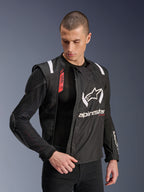 Veste Alpinestars T-Stunt Air, veste de moto noire et blanche portée par un mannequin homme, mettant en évidence la construction modulaire en mesh et les protections internes apparentes aux épaules et aux coudes, logo Alpinestars sur la poitrine, compatible Tech-Air®, coupe sportive pour la route