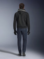 Alpinestars Chrome Superairflow Hoodie, sweat à capuche de moto noir avec logo blanc sur la capuche, vue de dos, porté avec un jean bleu foncé, des gants noirs et des bottes noires et blanches, équipement de conduite sportive urbaine