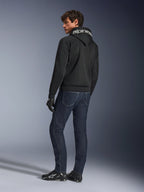 Hoodie Alpinestars Chrome Superairflow, noir, vue de dos sur mannequin homme, avec logo Alpinestars blanc sur la capuche, porté avec un jean en denim foncé et des gants noirs, design d'équipement de moto urbain