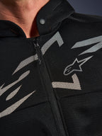 Alpinestars Chrome Superairflow Hoodie, sweat à capuche de moto, noir avec graphismes blancs et gris, gros plan sur le torse montrant la construction technique en maille 3D, fermeture éclair frontale et col à bouton-pression, arborant le logo Alpinestars