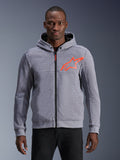 Alpinestars Chrome V2 Sport Hoodie in Graumeliert mit fluoreszierendem rotem Stern-Logo, schützender Motorrad-Hoodie mit Frontreißverschluss und Druckknopfkragen, von einem Model getragen, lässige urbane Fahrbekleidung mit Tech-Fleece-Konstruktion.