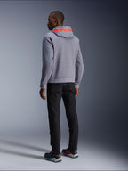 Alpinestars Chrome V2 Sport Hoodie in Gray Heather, Rückansicht mit großem Alpinestars-Schriftzug in Red Fluo auf der Kapuze, getragen von einem Model mit schwarzer Hose und dunklen Motorradschuhen, lässige urbane Motorradbekleidung