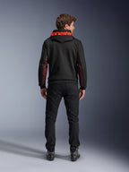 Alpinestars Chrome Air Sport Hoodie, Schwarz und Fluorot, Rückansicht eines Mannes, der eine lässige Motorradjacke trägt, mit rotem Alpinestars-Branding auf der Kapuze und roten Mesh-Einsätzen an den Ärmeln, kombiniert mit einer schwarzen Hose.