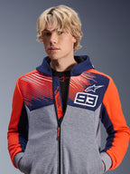 Alpinestars MM93 Chrome V2 Sport Hoodie, sweat à capuche moto urbain, bleu marine et gris chiné avec accents rouge fluo, arborant le marquage Marc Marquez 93 et le logo Alpinestars, design à fermeture éclair intégrale, vêtement lifestyle décontracté pour les motards