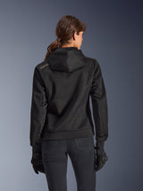 Alpinestars Stella Chrome Superairflow Hoodie, back view of woman wearing black technical 3D mesh motorcycle hoodie, features engineered hood and copper logo on shoulder, worn with black motorcycle gloves and pants.
