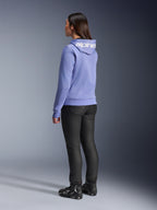 Alpinestars Stella Chrome V2 Sport Hoodie voor dames, blauw violet, achteraanzicht met witte branding op de capuchon, gedragen met zwarte motorbroek en zwarte motorlaarzen, casual stedelijke motoruitrusting
