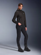 Alpinestars Stella Radium Tech Hoodie, zwarte urban motorhoodie voor dames, gedragen met een zwarte motorbroek en tactische laarzen, slanke atletische pasvorm, winddichte 3-laags tech-shell, minimalistisch ontwerp met klein logo op de borst, volledige studio-opname