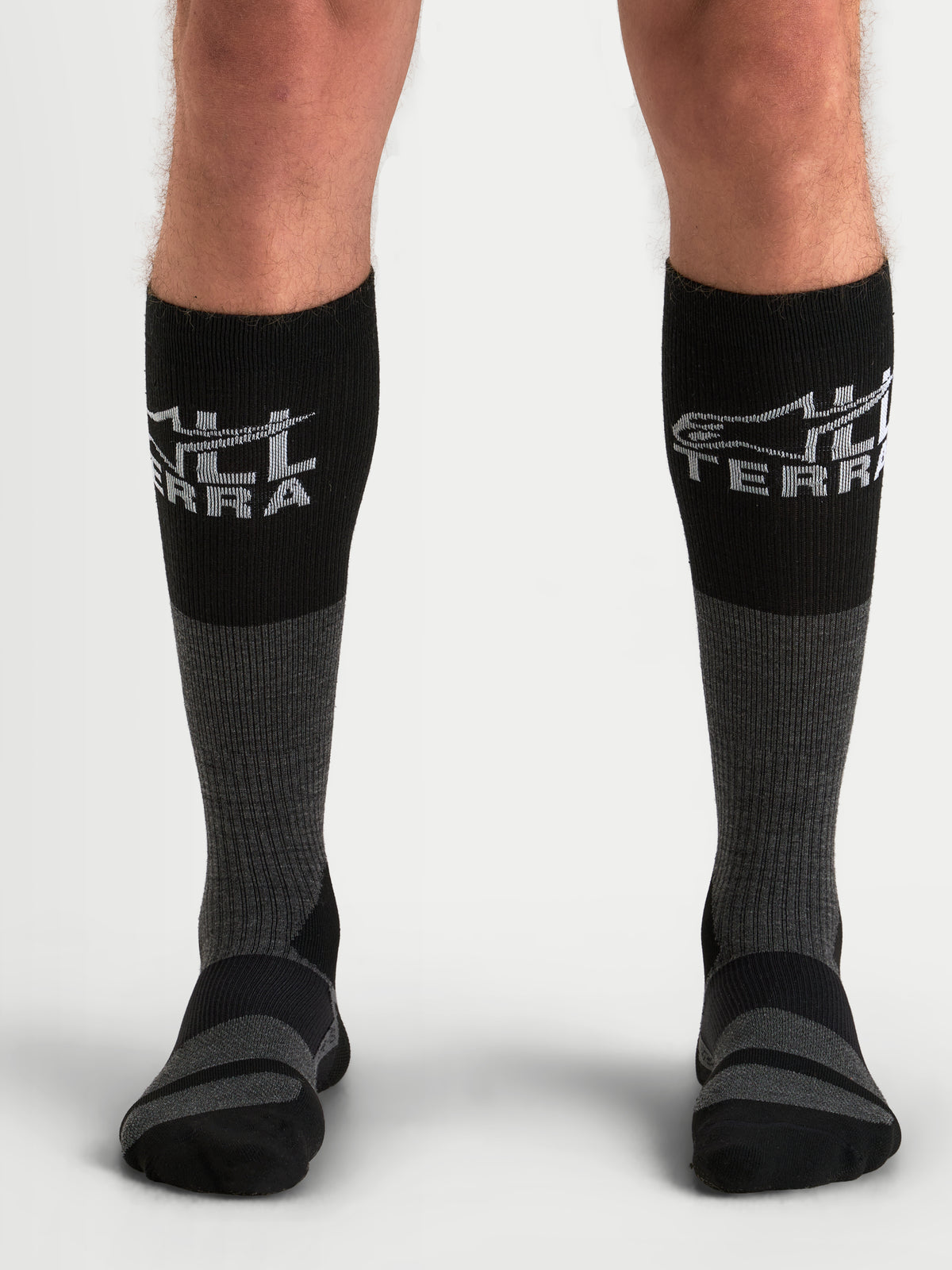 Alpinestars AT-8 Merino sokken, avontuurlijke motorsokken voor heren in teergrijs en zwart, thermische merinomix performance-kleding gedragen op model met geribbelde kuit en versterkte dempingszones