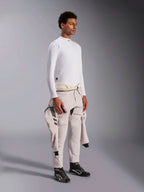 Alpinestars ZX Evo V3 Top met lange mouwen, witte vlamvertragende auto racing base layer, gedragen door een model met een racepak om de middel geknoopt, lichtgewicht technische laag met opstaande kraag en logodetail.