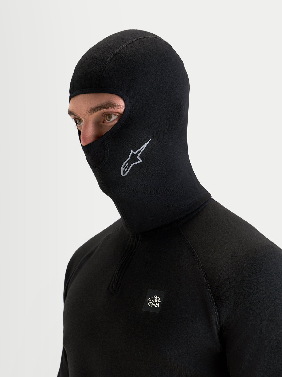 Alpinestars At 8 Merino bivakmuts, zwarte technische motorbivakmuts gedragen door een model, met merinomix thermische constructie en verlengde nekbedekking