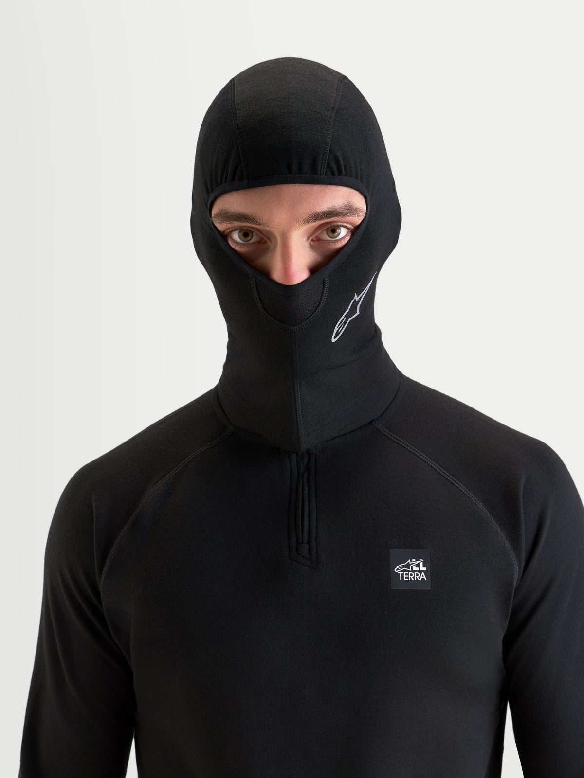 Alpinestars At 8 Merino bivakmuts, zwarte motorbivakmuts en thermische basislaag gedragen door een model, met merinomix thermische constructie en open gezichtsontwerp