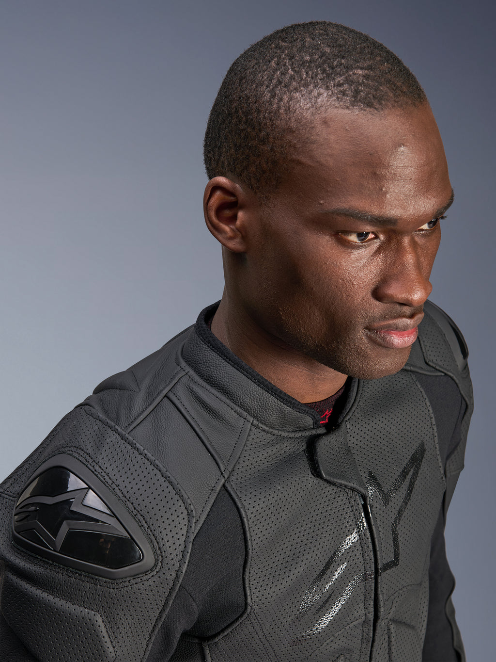 Close-up van een model dat de Alpinestars Dusk Airflow Leren Jas draagt, Black on Black, met uitgebreid geperforeerd leer voor ademend vermogen, externe DFS-schoudersliders en een strak modern ontwerp voor sportief rijden.