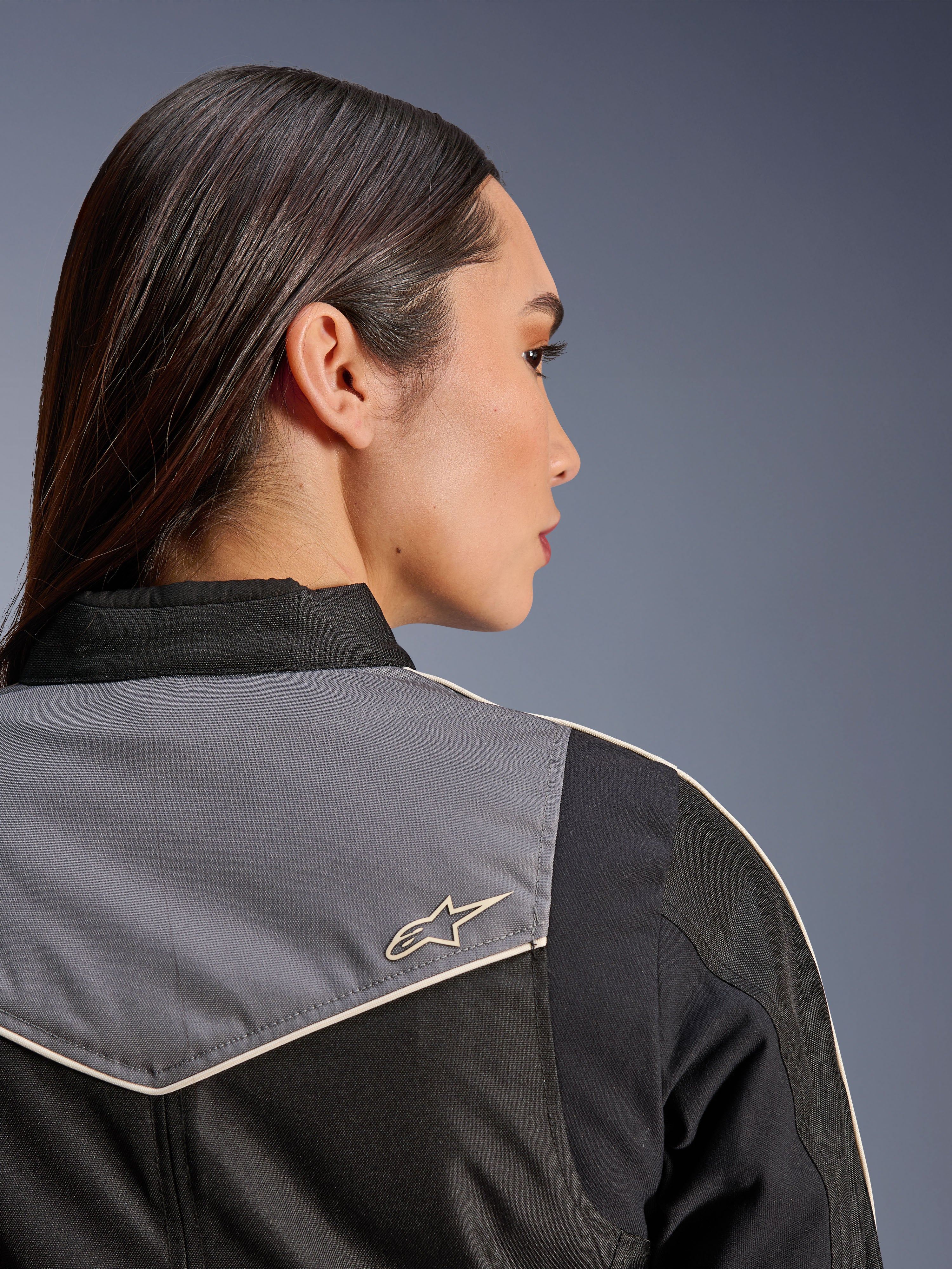 Alpinestars Stella T-Dyno WR Jacket, Women's Motorcycle Jacket, Black Dark Gray and Ecru, close-up back view of shoulder and yoke featuring gray panel with ecru star logo, vintage-inspired riding gear