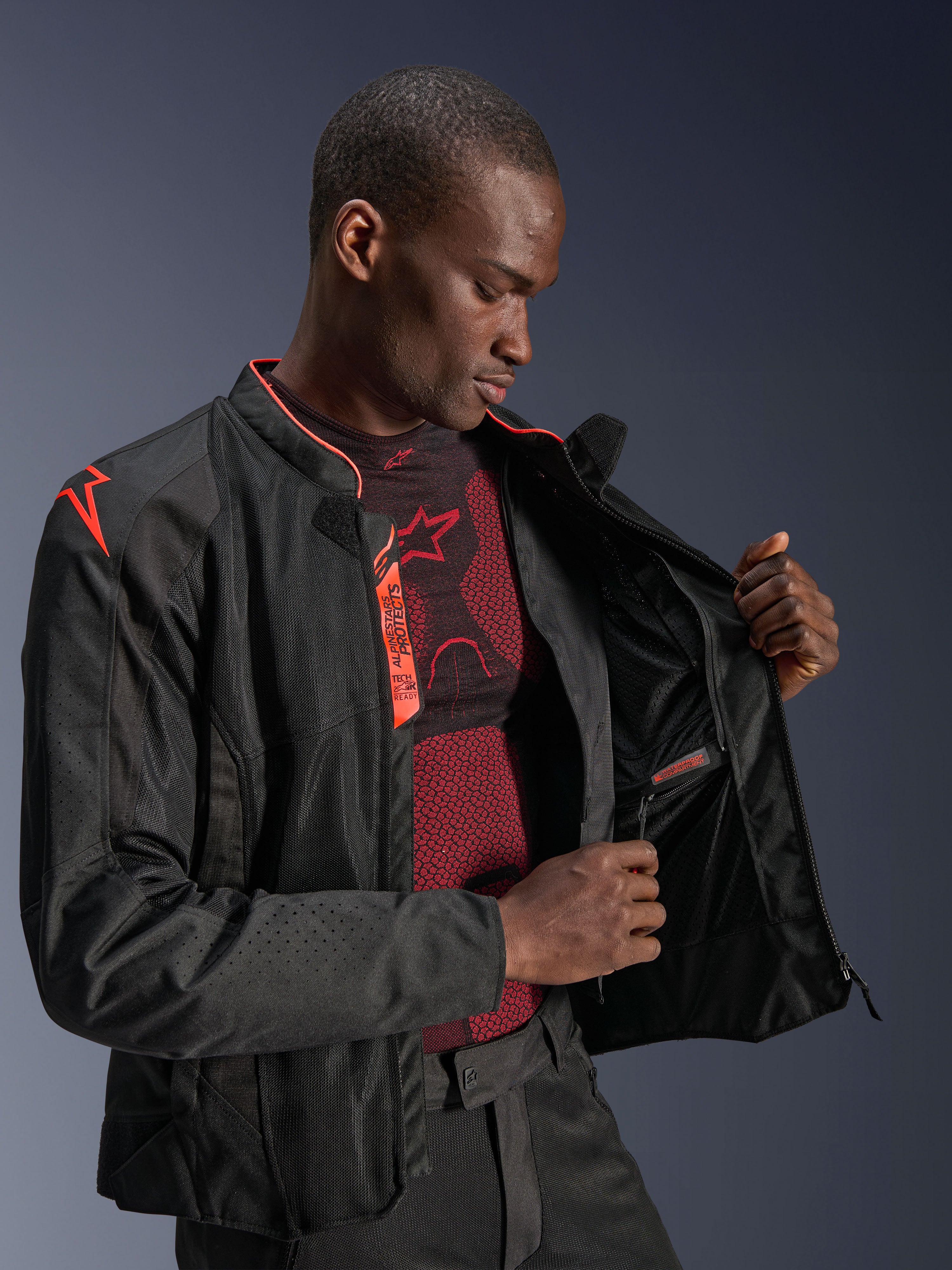 Veste Alpinestars Viper Air V4, Noir et Rouge Fluo, veste de moto avec panneaux en maille technique, mannequin homme présentant le compartiment intérieur étanche et la doublure, avec détails rouge fluo et marquage Tech-Air Ready